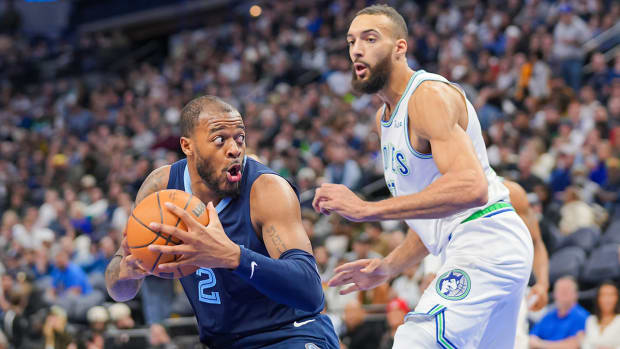 Former Memphis Grizzlies forward Xavier Tillman Sr. controls the ball against Rudy Gobert of the Minnesota Timberwolves.